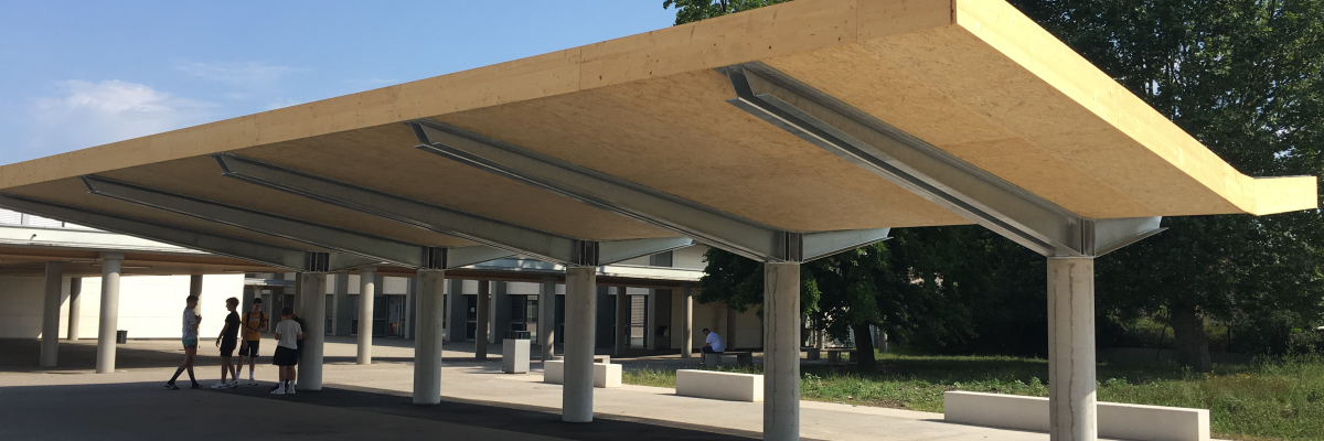 Station de bus avec abris, bancs et véhicules.