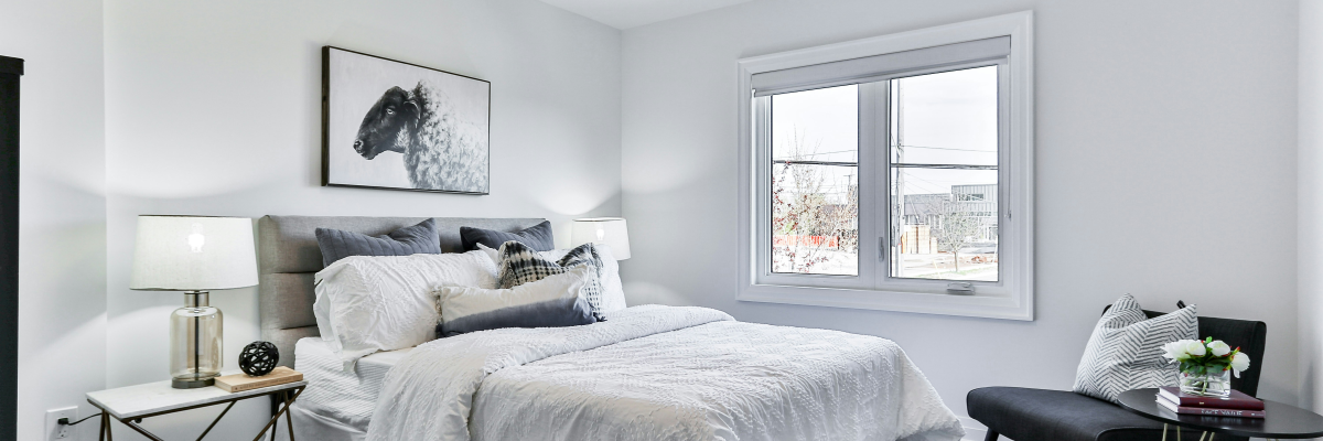 Chambre avec lit, table de chevet, lampe, œuvre d'art, table, chaise.