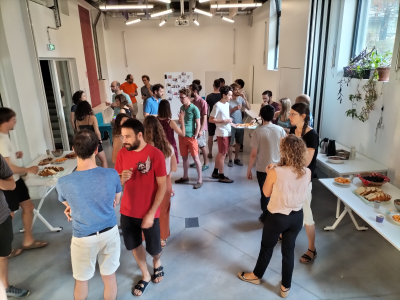 Salle avec personnes, buffet, tables, plantes et porte.